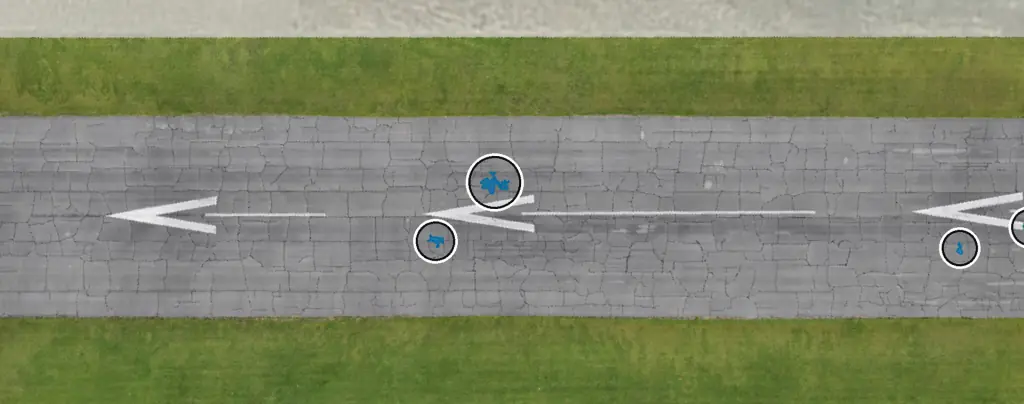 Cracked runway section from directly above with HALO AI's standing-water layer, blue patches circled where water collects in low spots